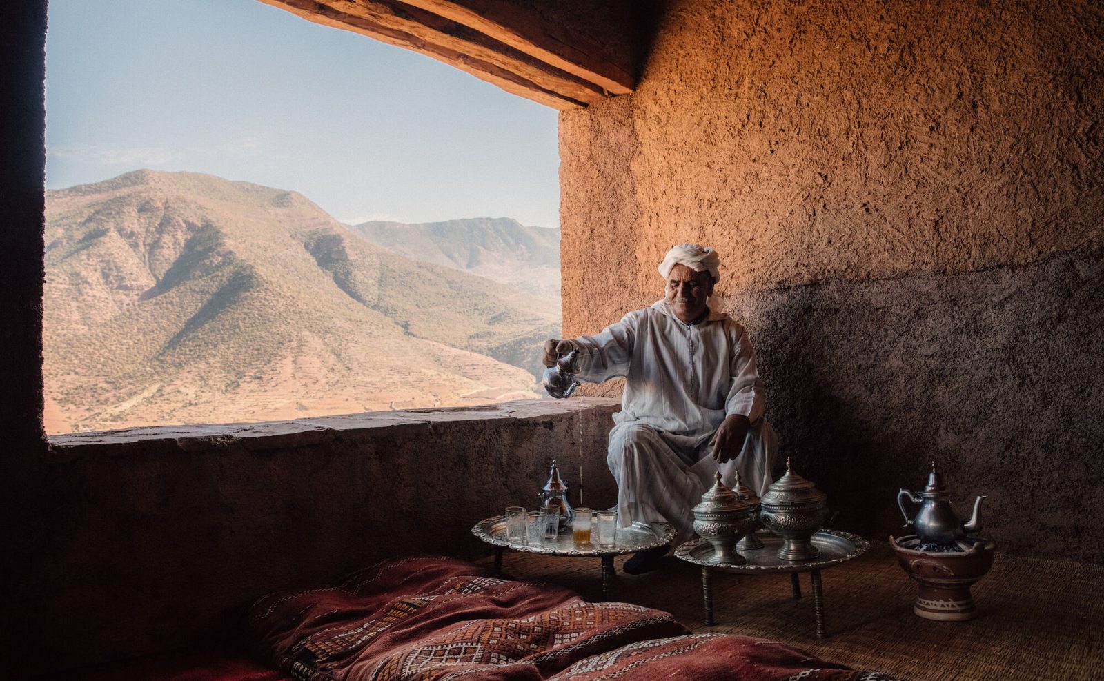 A Moroccan host pouring tea overlooking the Atlas Mountains, Amanjena