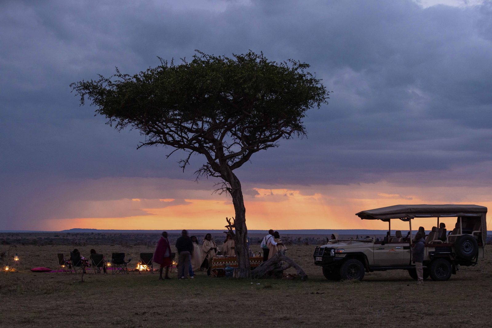 Safari sundowners under an acacia tree at dusk, Mahali Mzuri, Kenya