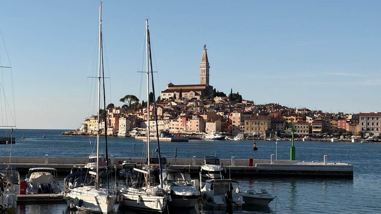 The old town of Rovinj, Croatia, rising behind a marina, with the bell tower of the church of St Euphemia above the rooftops