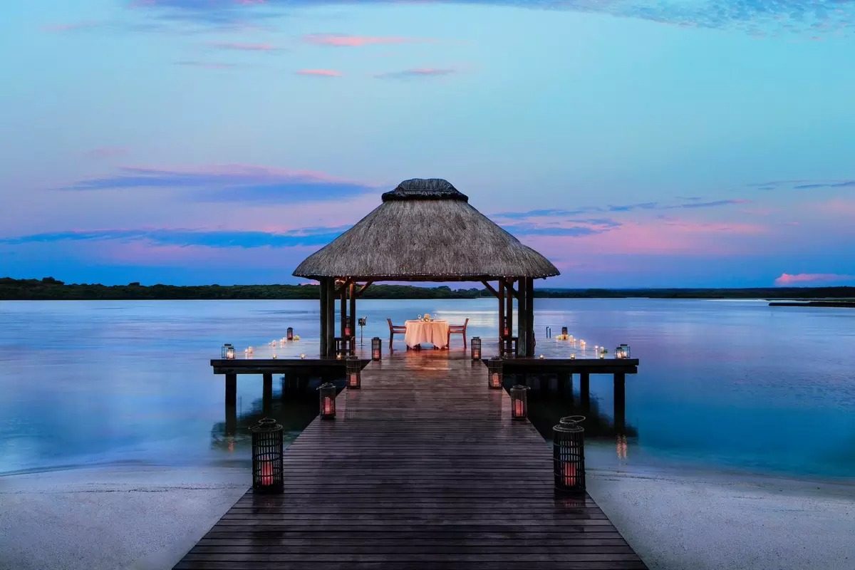 Private candlelit dining pavilion on an overwater jetty at twilight, One&Only Le Saint Géran, Mauritius